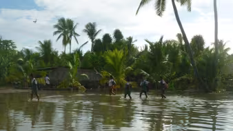 People walk through a flooded area in Kiribati