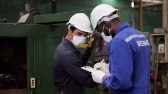 Two engineering workers wearing face masks at factory