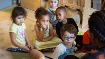 A group of preschoolers listen to a story