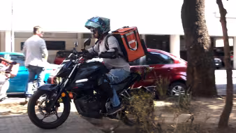 Food delivery service driver on a motorcycle in Mexico