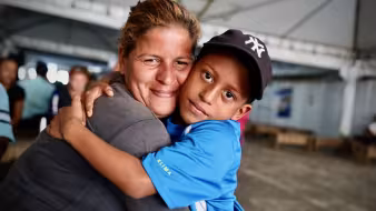 Venezuelan mother and son embrace at a reception center in Brazil
