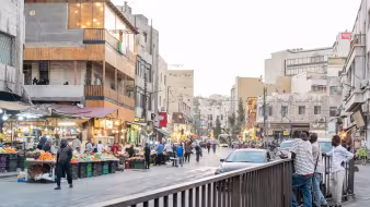 A street in Amman, Jordan, with market stalls, people, and cars