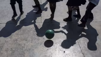 Children at a school in Honduras play with a soccer ball