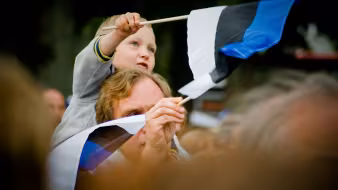 A father and son wave flags at the Estonian Song Festival in Tallinn.