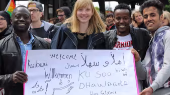 Four people stand with a sign at a demonstration