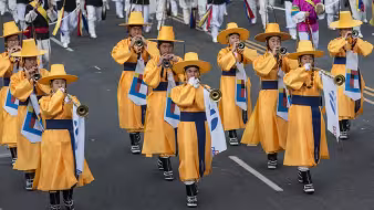 Korean band members march in a parade