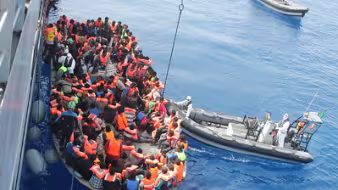 Migrants aboard a rubber vessel are rescued in the Mediterranean