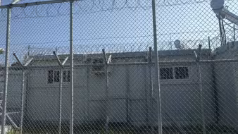 Buildings behind a barbed wire fence