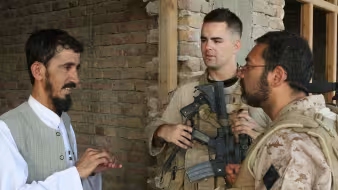 An Afghan man speaks to an interpeter working with the U.S. Marine Corps.