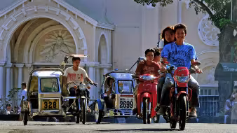 Young people ride motorcycles in Batac, Philippines.