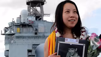 A woman stands onboard the U.S. Navy vessel on which she was born.