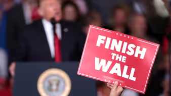 A supporter holds a sign reading "Finish the Wall" during a rally for President Donald Trump in Mesa, Arizona.