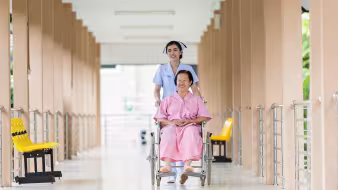 A nurse assists a woman in a wheelchair