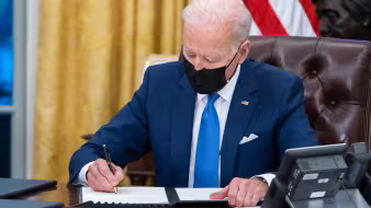 President Joe Biden signs executive orders on immigration in the White House.