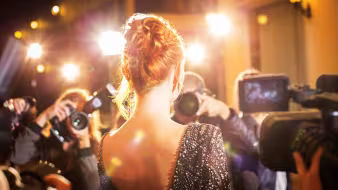A female celebrity being photographed at an event.