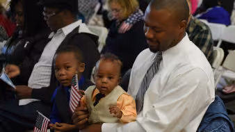 A man and child at a naturalization ceremony outside Washington, DC.