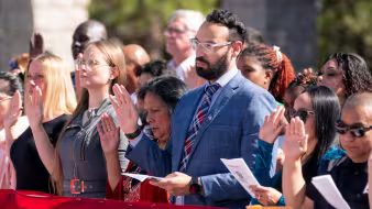 Immigrants take the oath of allegiance during a naturalization ceremony.