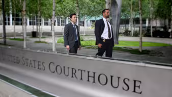 U.S. immigration officials walk by a courthouse in Seattle.