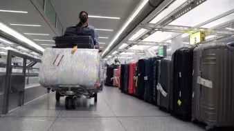 A person walks with luggage in John F. Kennedy International Airport in New York City.