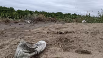 An abandoned shoe lies in the mud along the U.S.-Mexico border.