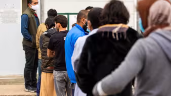 Afghan parolees wait in line at Fort McCoy, Wisconsin.