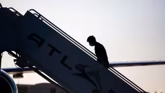 A man boards a repatriation charter flight to Guatemala.