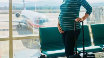 A pregnant woman at an airport.