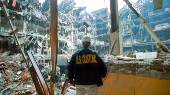 A U.S. Customs agent looks at wreckage following the 9/11 terror attacks