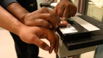 An officer in the Harris County (TX) Sheriff's Office takes the fingerprints of an individual it arrested. Harris County has a 287(g) agreement with ICE.