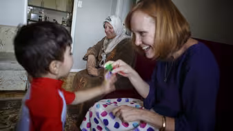 A private refugee sponsor in Canada plays with a boy.