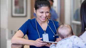 A nurse looks at a baby.