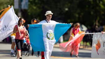 Un hombre portando la bandera de Guatemala en un desfile en Washington, DC
