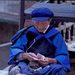 An elderly woman counts money in China.(Photo: Curt Carnemark/World Bank)